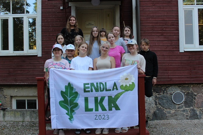 noored koos Endla LKA lipuga seisavad looduskeskuse hoone trepil