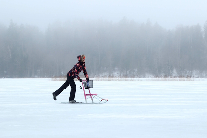 üksik naine sõidab soome kelguga järvejääl