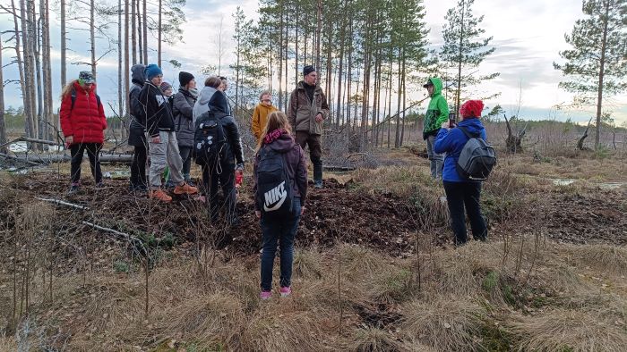 grupp seisab turbast tehtud tammil mille taga on üles paisutatud soovesi