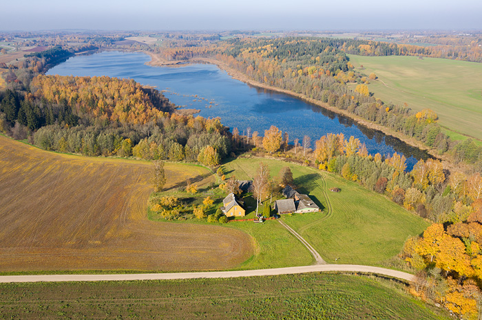 a aeral view with a farmhouse, forest, fields and lake Pikkjärv in autumn