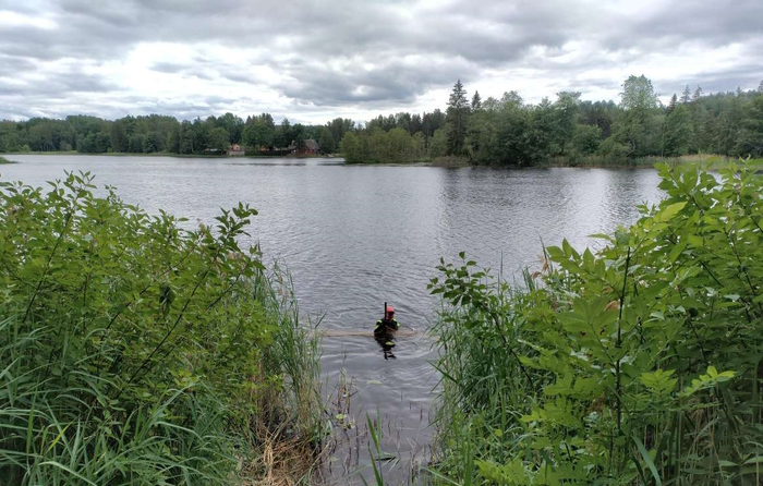 mees on kaldalähedases vees rinnuni sees, näha on ta käes üks pikk tokk